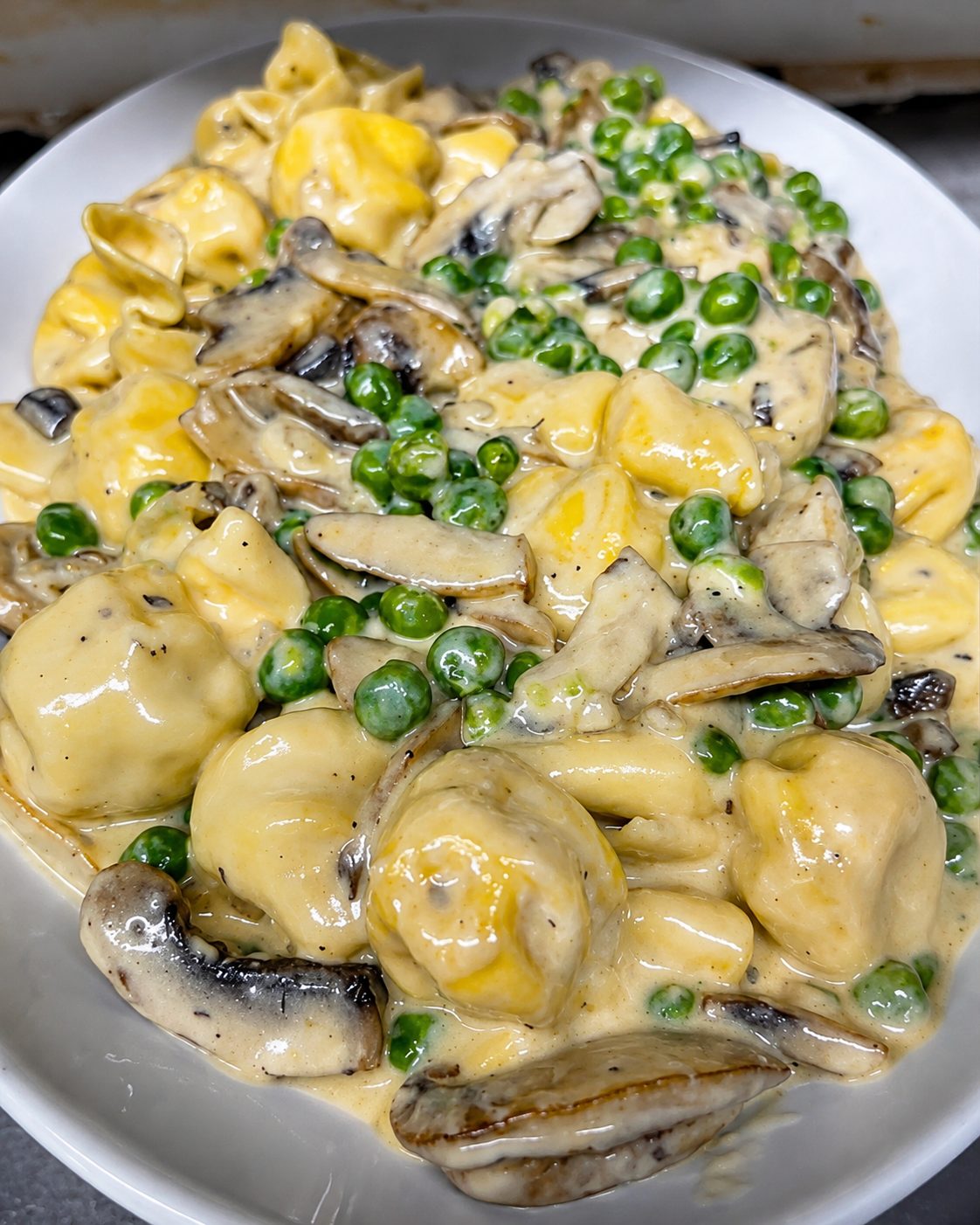 Tortellini with peas and mushrooms in cream